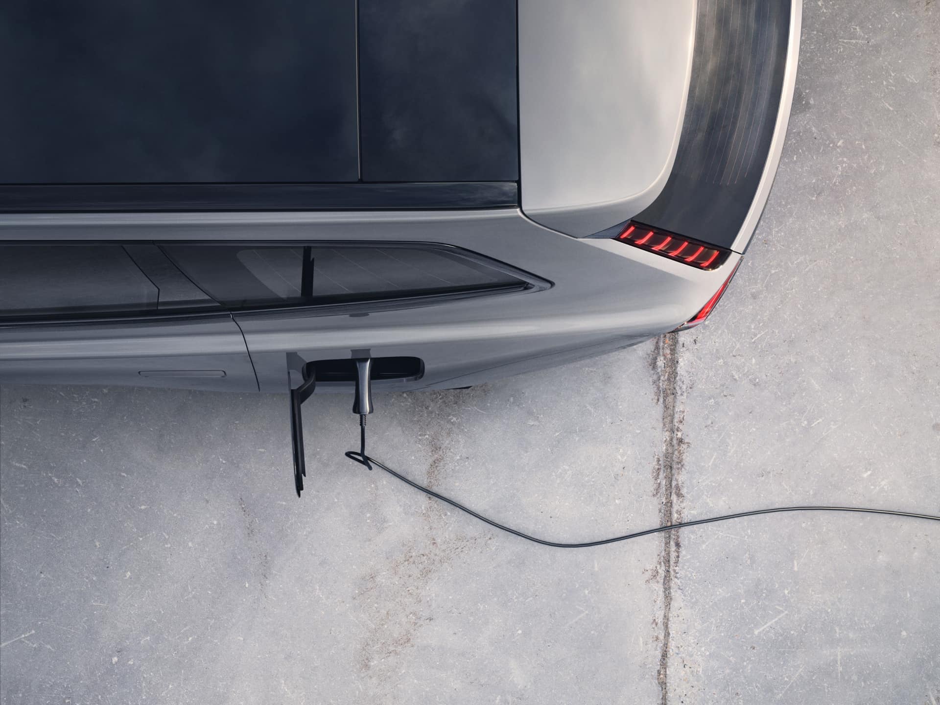 Ein Bild, das ein Ladekabel zeigt, das an einen Volvo EX90 angeschlossen ist.