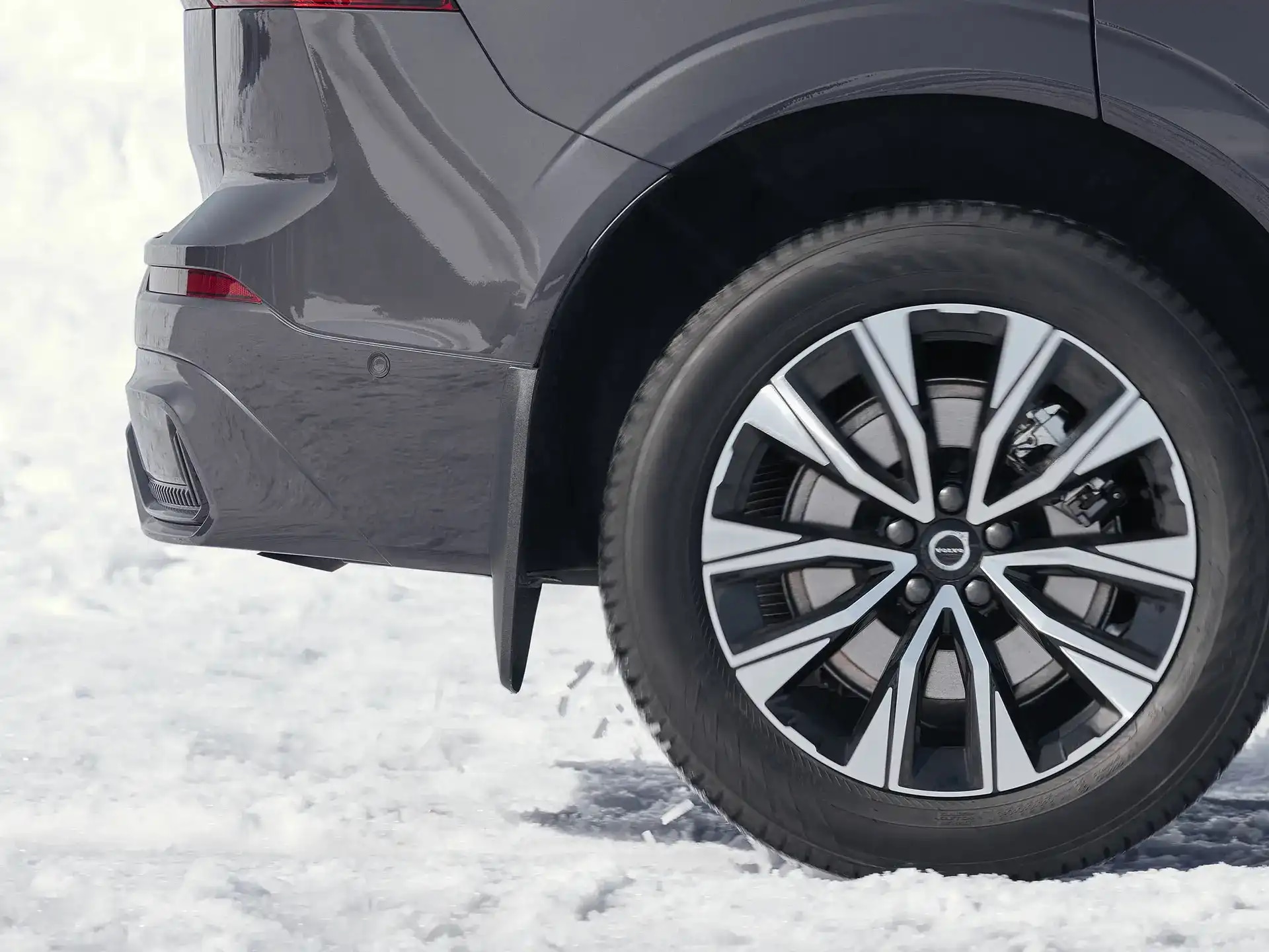 Seitenansicht eines Volvo Fahrzeugs auf einer verschneiten Straße mit montiertem Volvo Schmutzfänger.