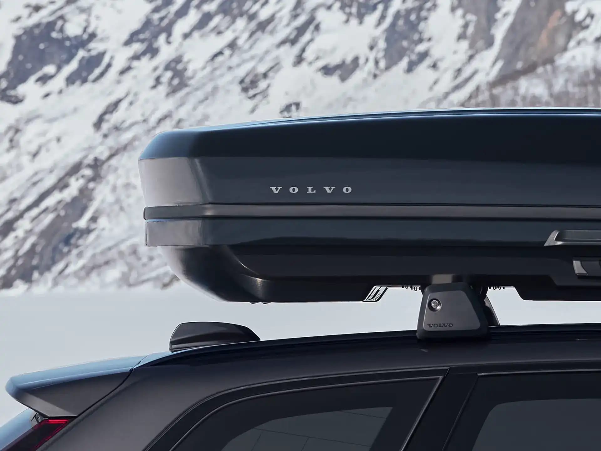 Eine Volvo Dachbox auf einem in winterlicher Umgebung geparkten Volvo Fahrzeug.