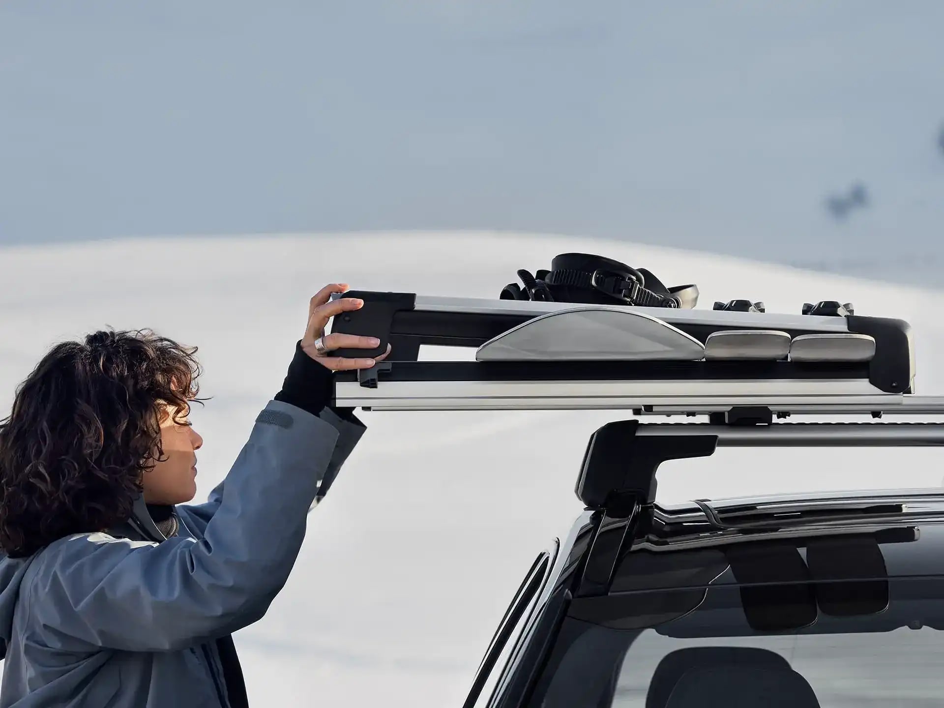 Eine Person nimmt ihre Skiausrüstung von einem Volvo Skiträger.