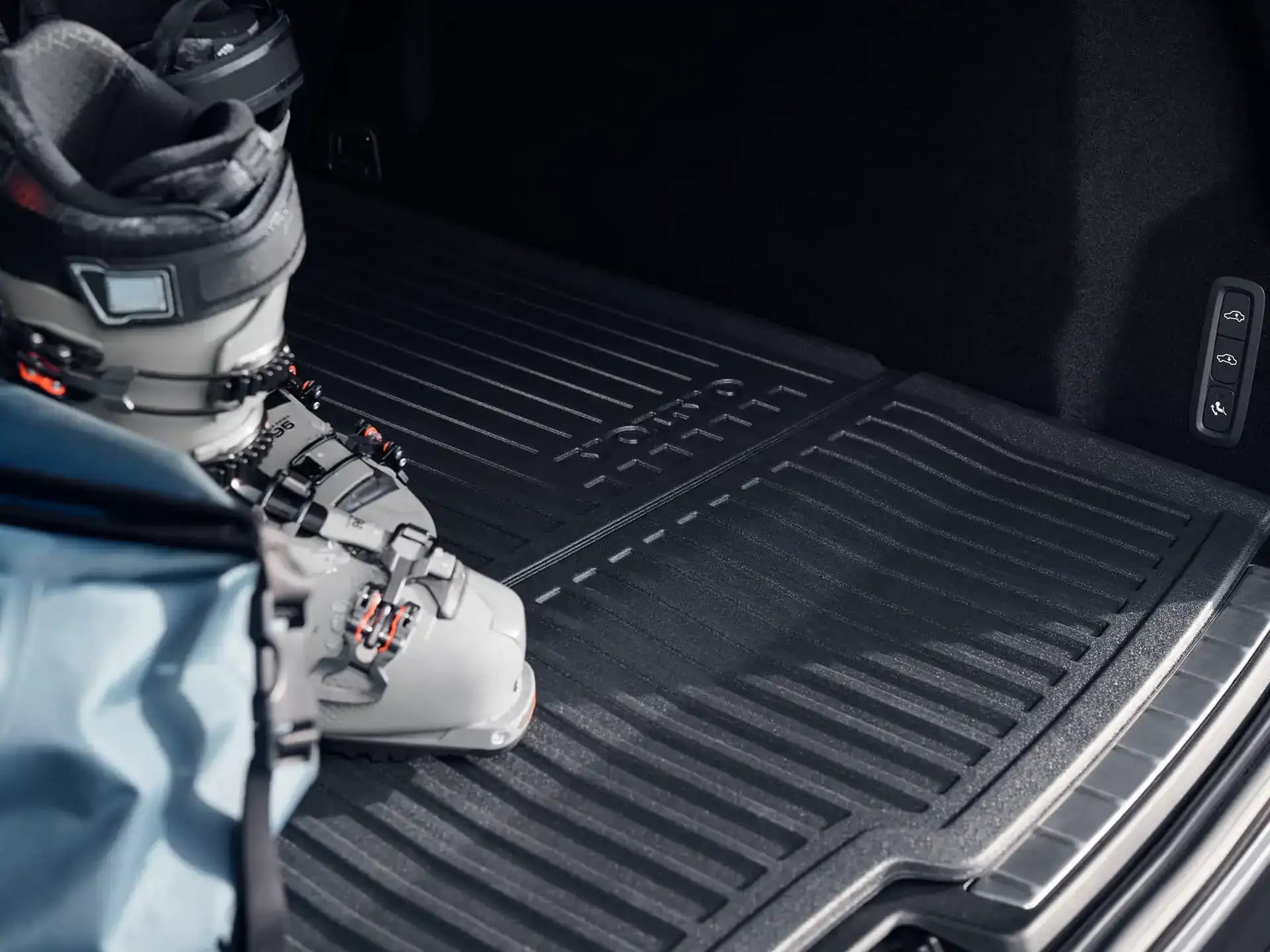 Ein Schneestiefel und eine Tasche auf der Laderaummatte eines Volvo Fahrzeugs.
