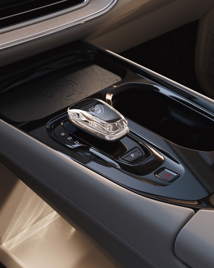 Close-up of the Orrefors crystal gear shift, wireless charger and storage featured in the fully electric EM90.