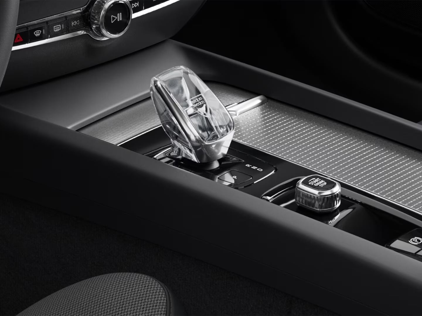 Start button and crystal gear shifter in the metal mesh-trimmed center console of the Volvo S60 mild hybrid.