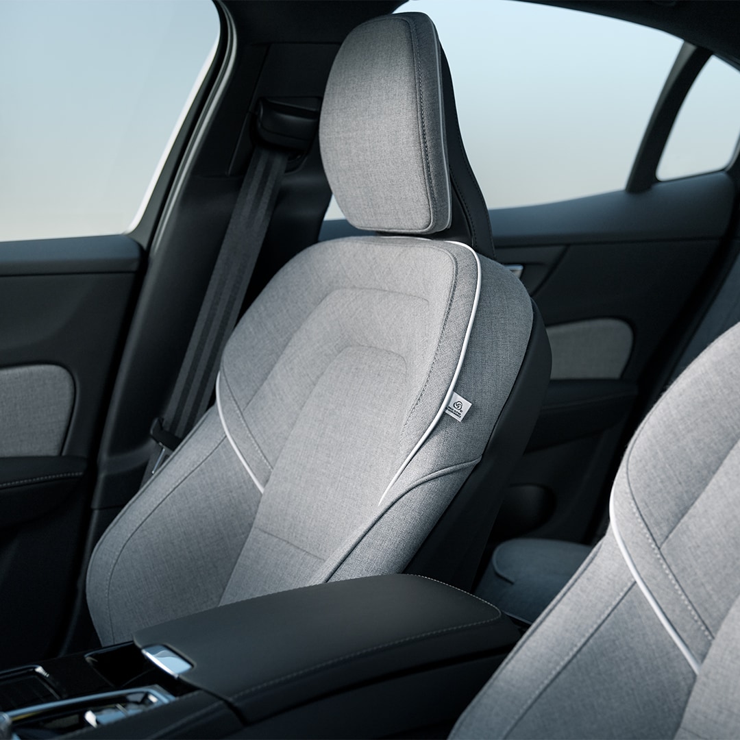 The Volvo S60 Recharge plug-in hybrid’s front passenger and driver’s seats in grey Tailored Wool Blend upholstery with white trim.