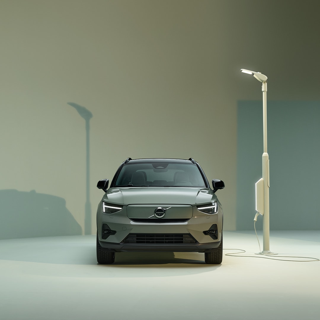 Volvo XC40 Recharge pure electric exterior front design with charger and charging station.