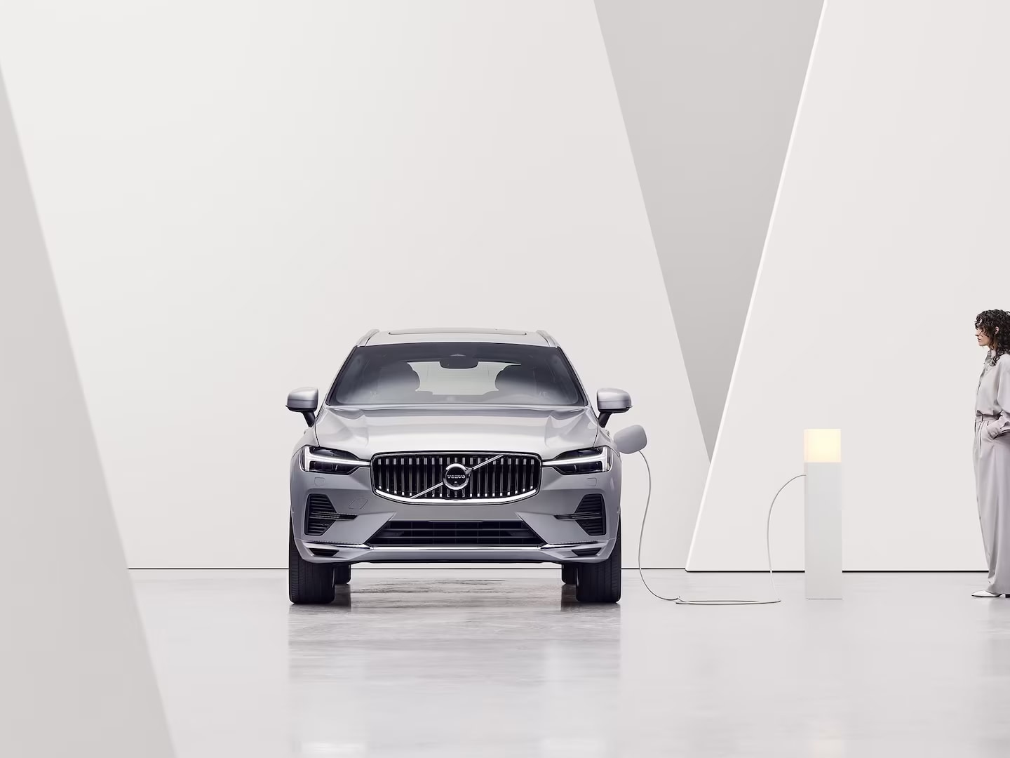 A Volvo XC60 Recharge plugged into a charging pole, being charged.