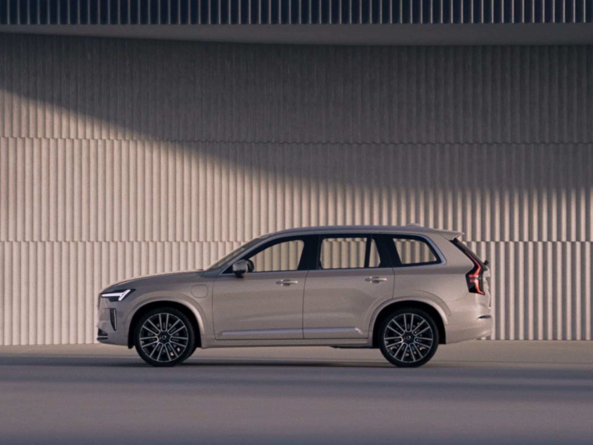 The side profile of a Volvo XC90 plug-in hybrid SUV.