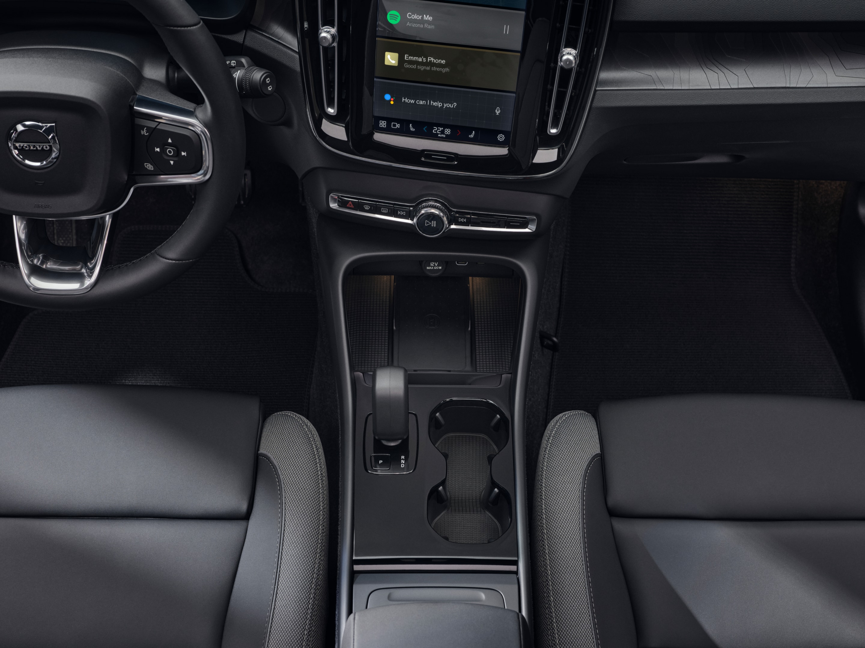 The cupholder, gear shift and wireless charger positioned between the front seats of the fully electric Volvo EX40.