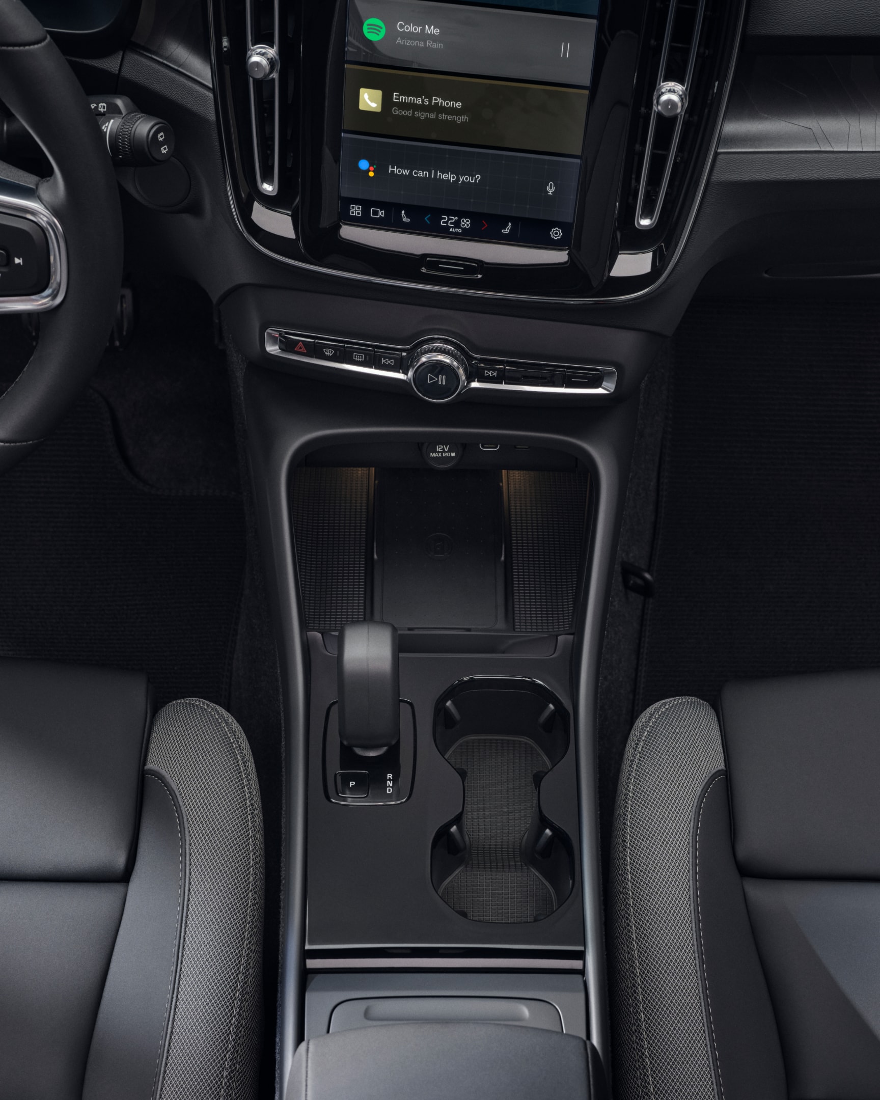 The cupholder, gear shift and wireless charger positioned between the front seats of the fully electric Volvo EX40.