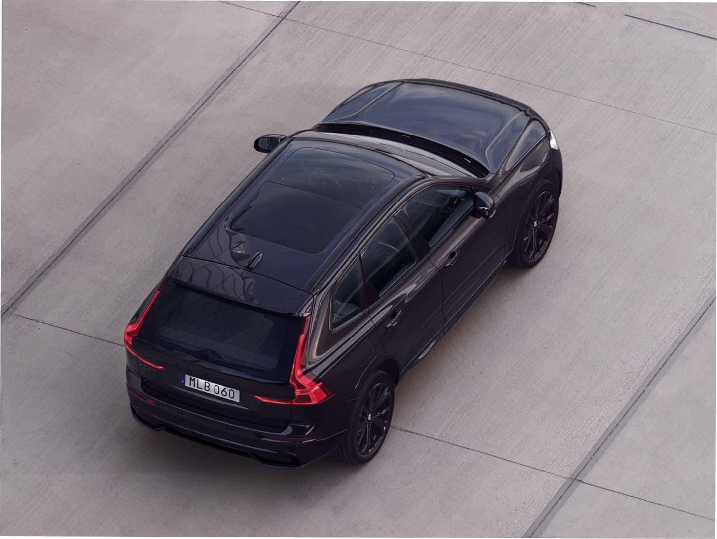 Un Volvo XC60 Black Edition mild hybrid deplasându-se în aer liber.
