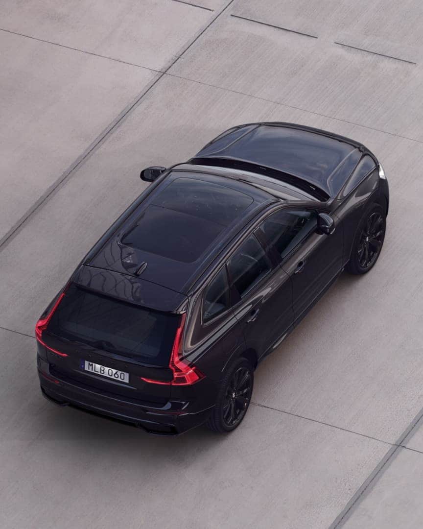 Мягкий гибрид Volvo XC60 Black Edition в движении на открытом воздухе.