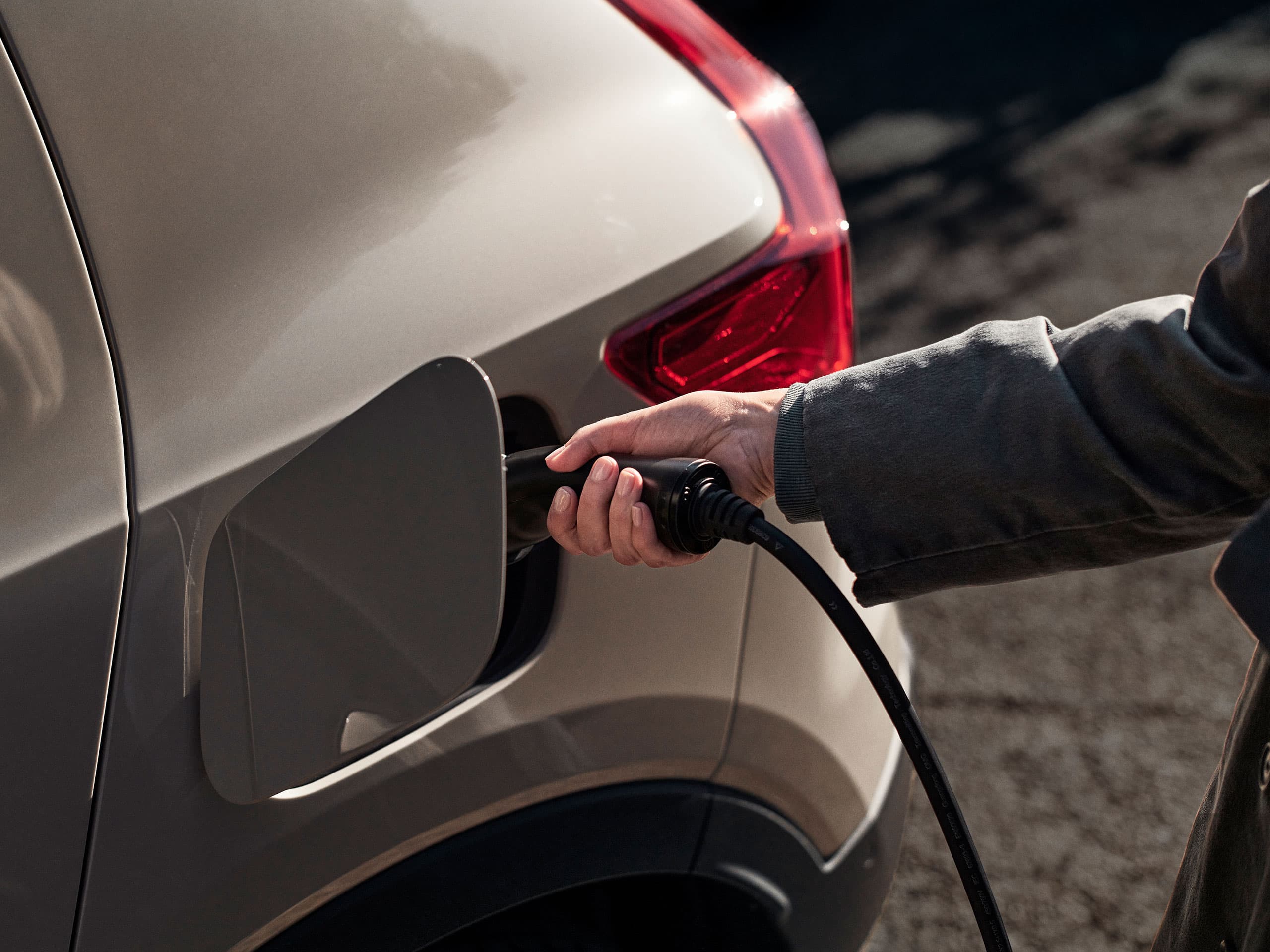 Image of a white Volvo connected to a charging point.