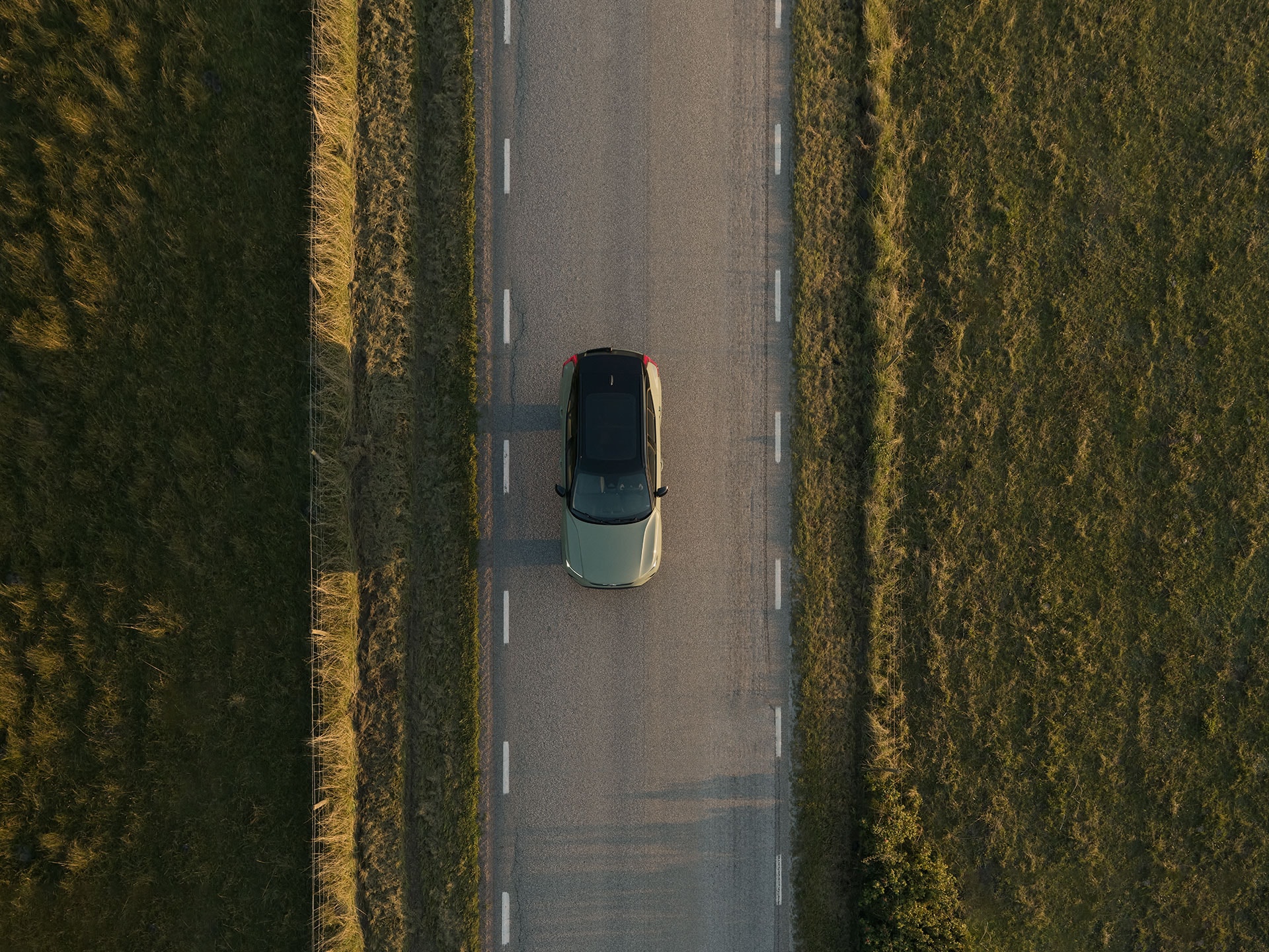 En helt elektrisk Volvo kör på en landsväg.