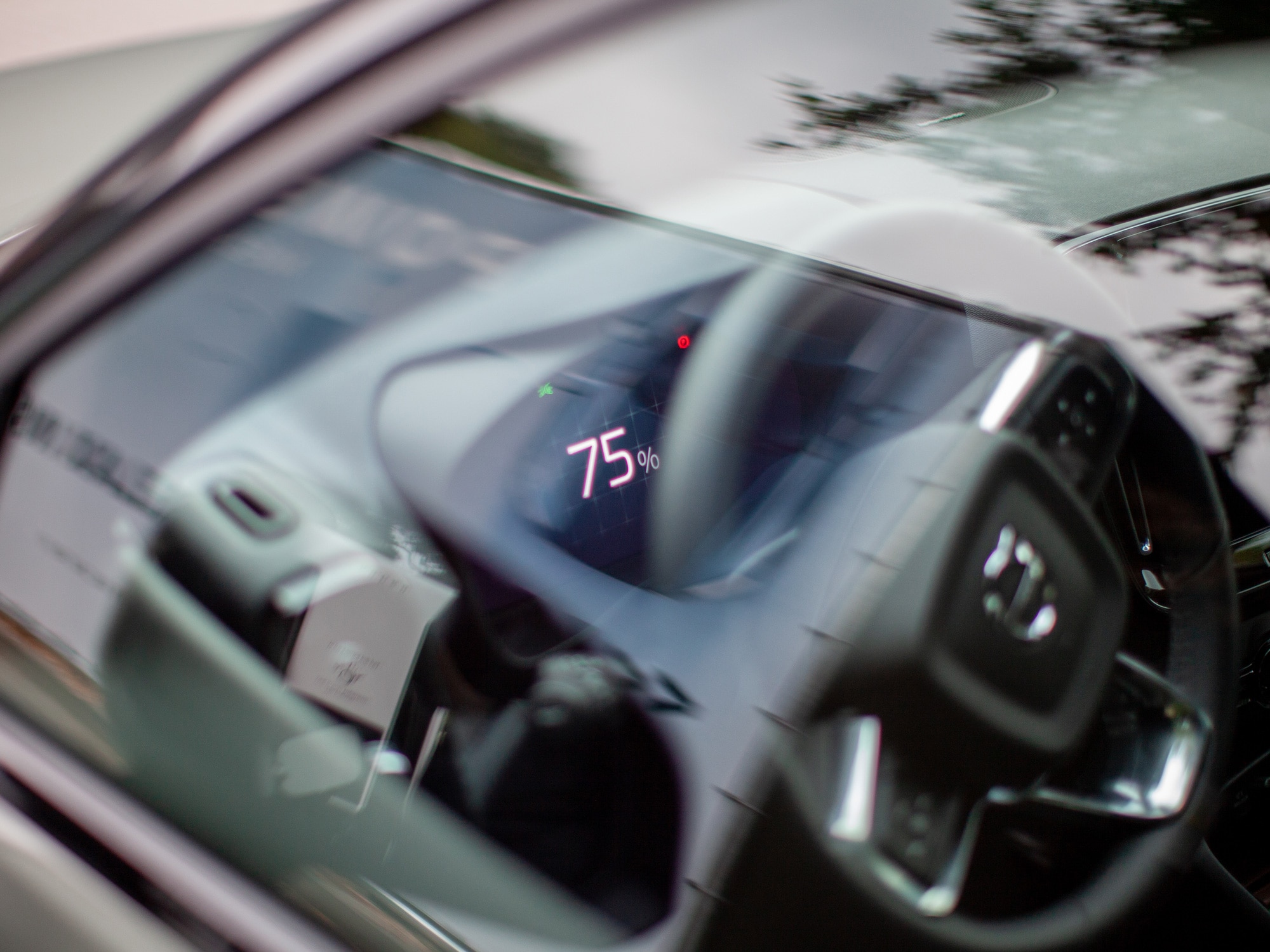 Affichage du pourcentage de charge de la batterie sur l'écran d'une Volvo C40 à travers la vitre latérale.