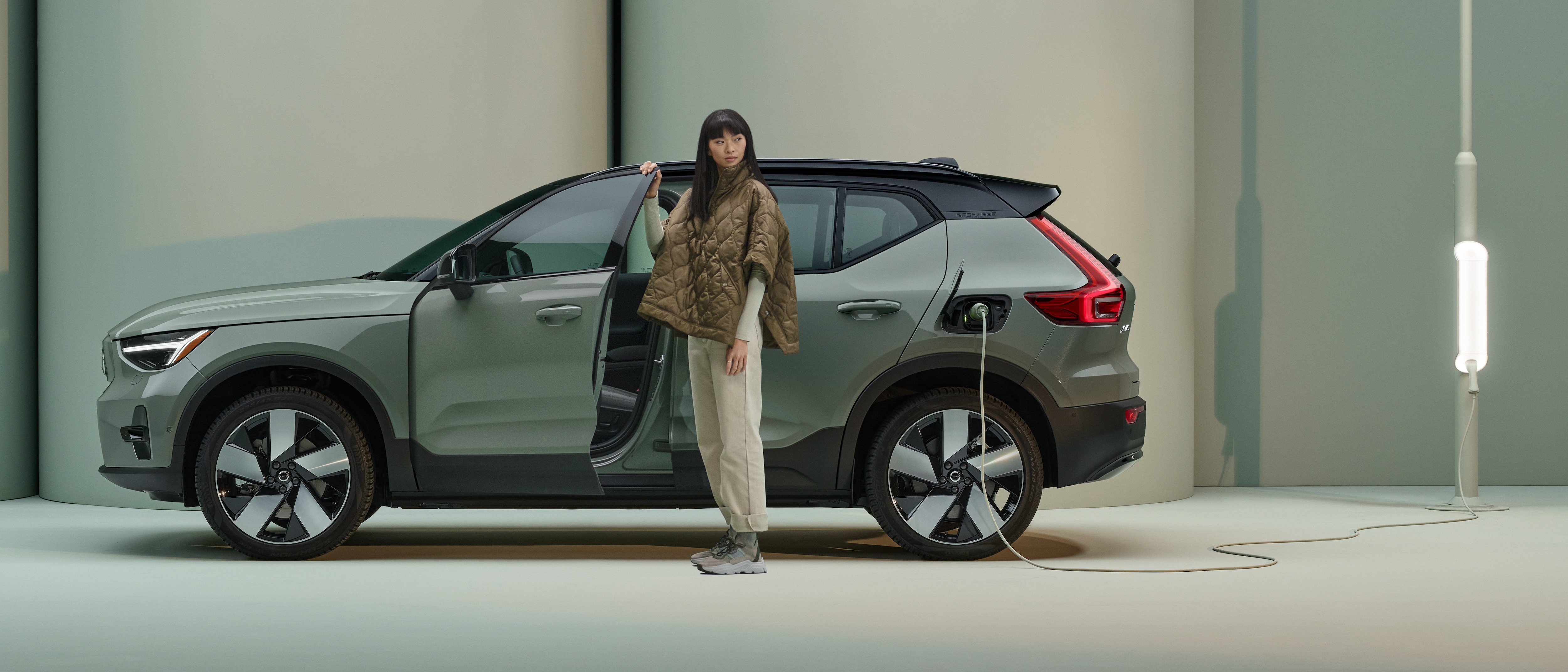 Woman standing outside of an XC40 Recharge while it's charging.
