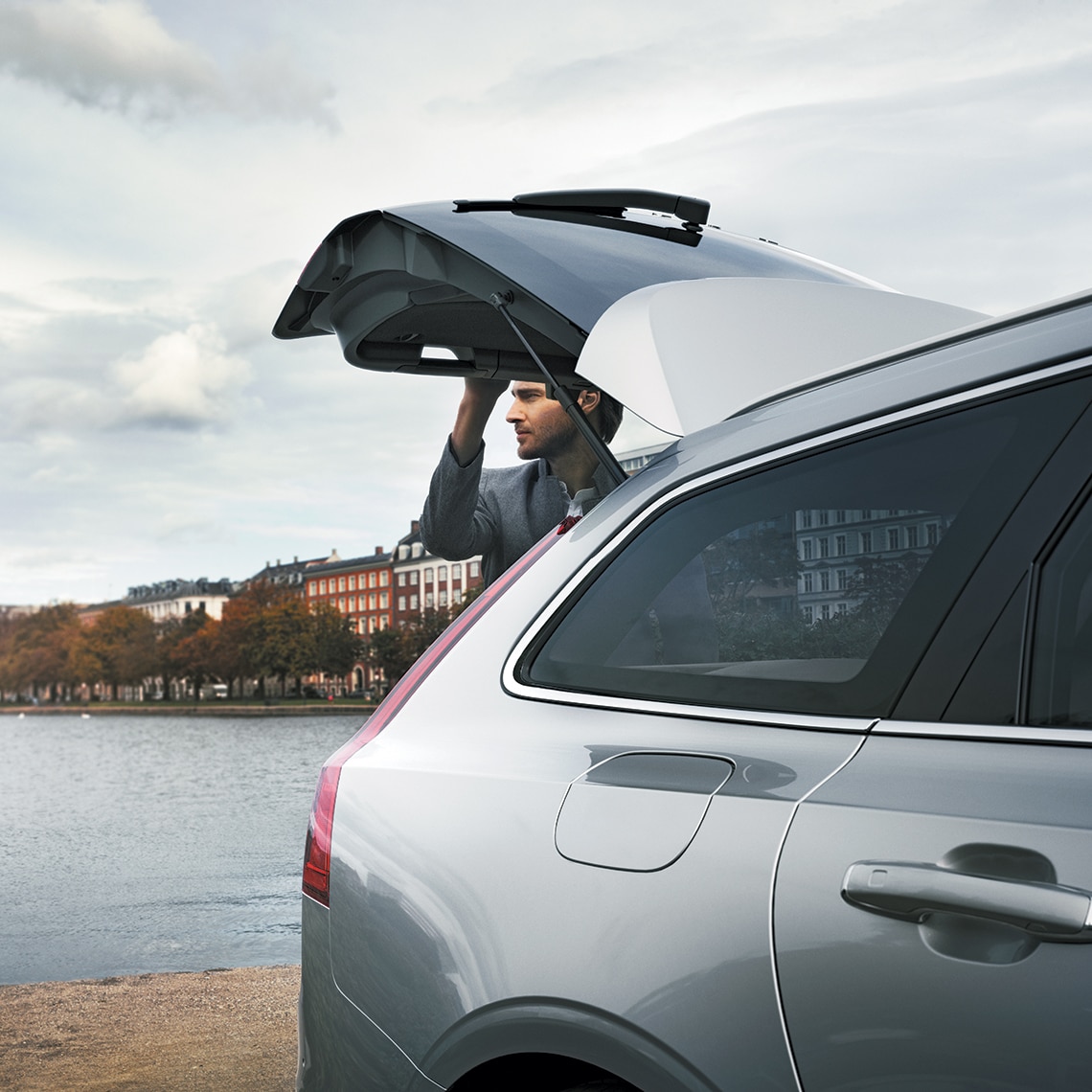 Homme fermant le coffre d'une voiture Volvo