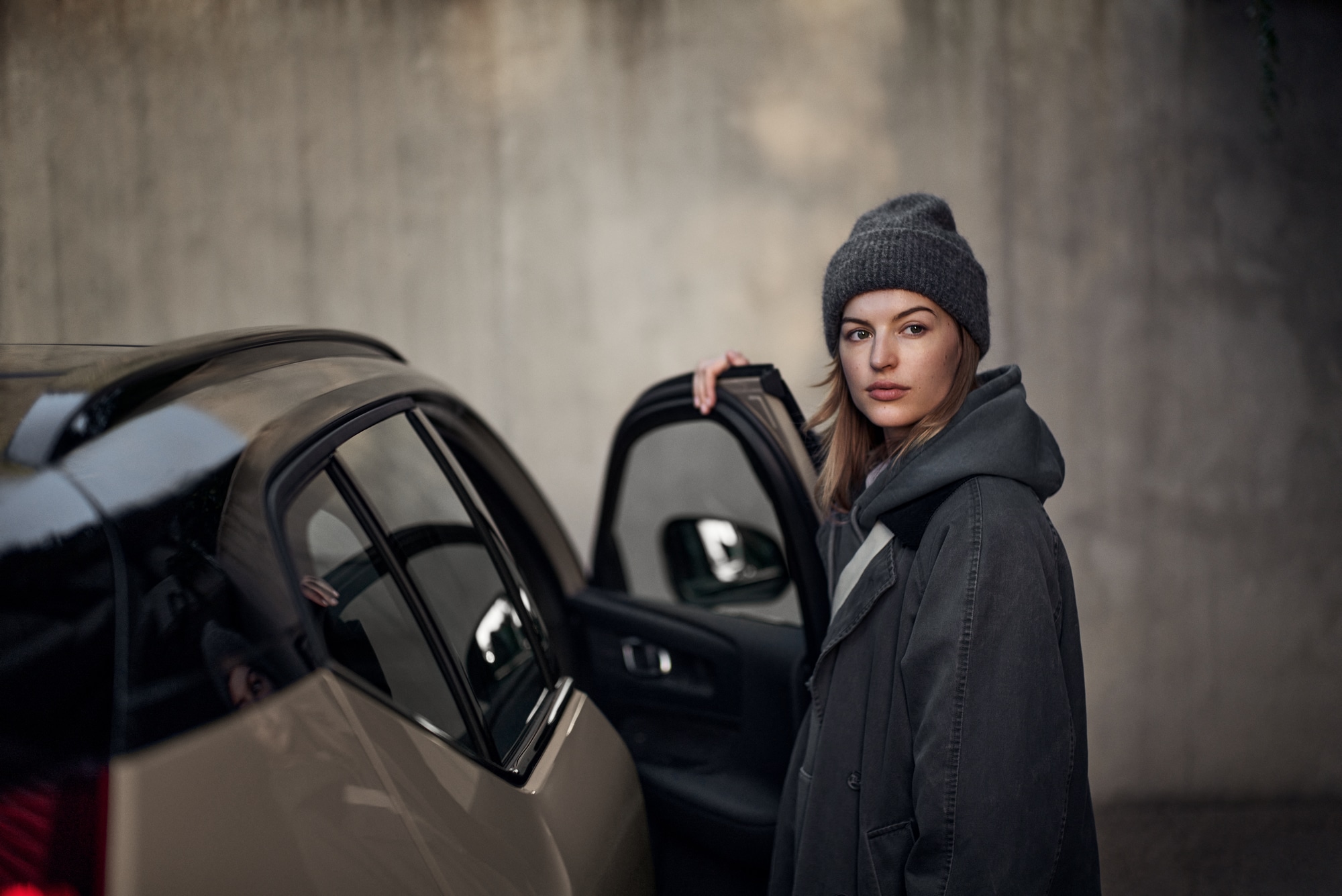 Femme a coté d'un Volvo EX40 avec la porte ouverte