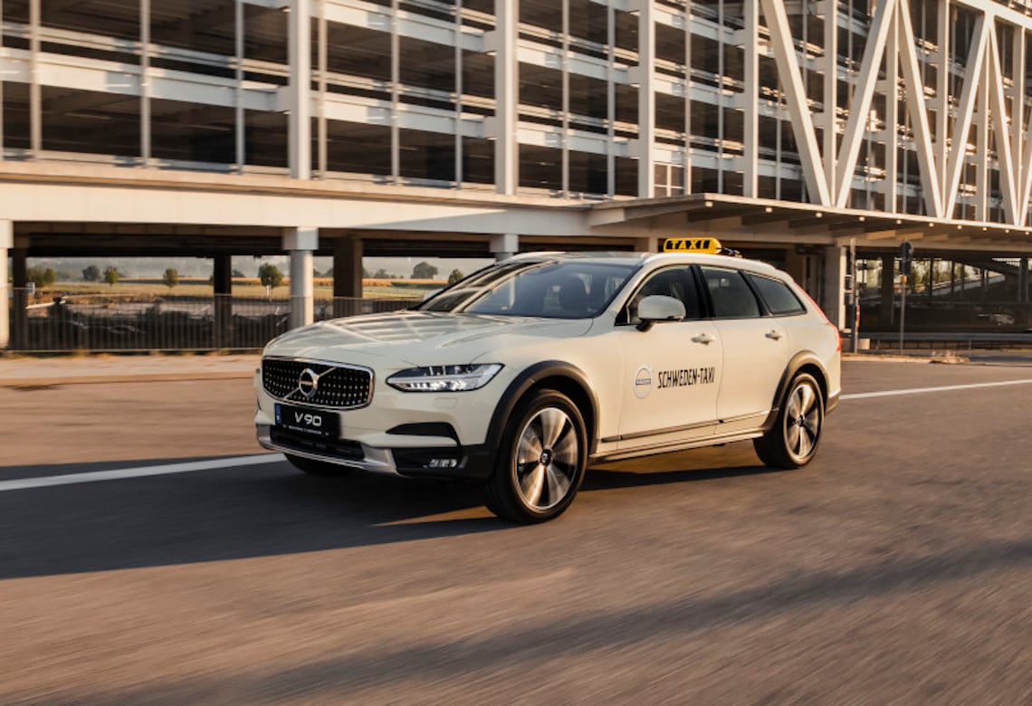 Ein Volvo Taxi fährt bei Sonnenaufgang über eine Strasse