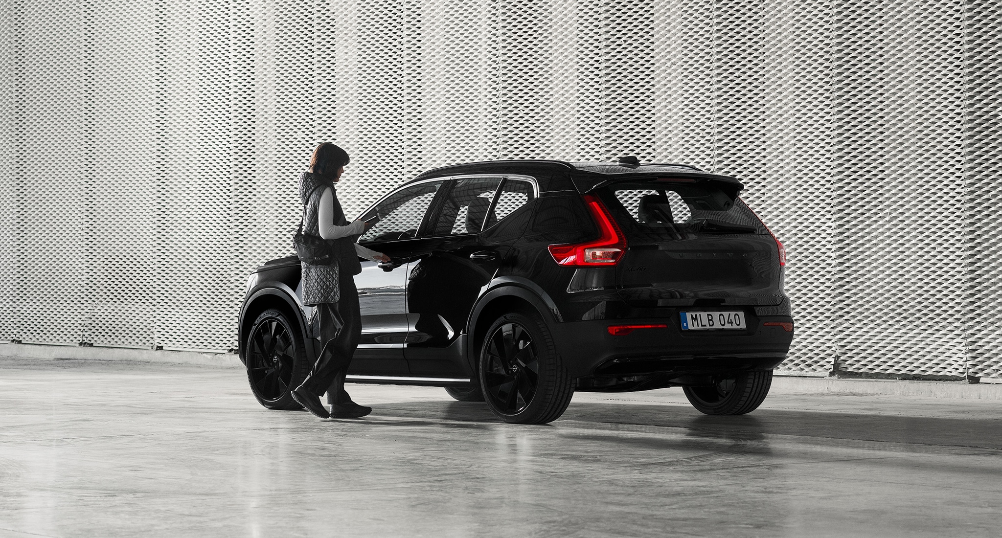 Eine Frau an einem Volvo XC40 Mild-Hybrid in der Black Edition.