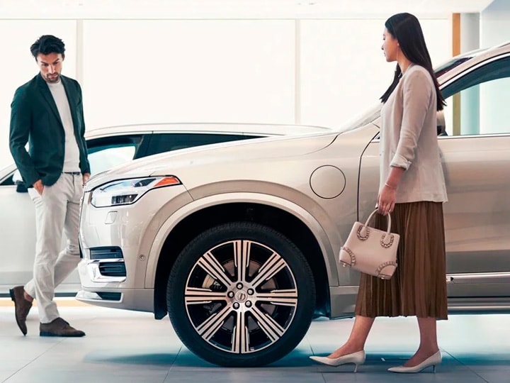 Una pareja mirando un vehículo Volvo en un concesionario