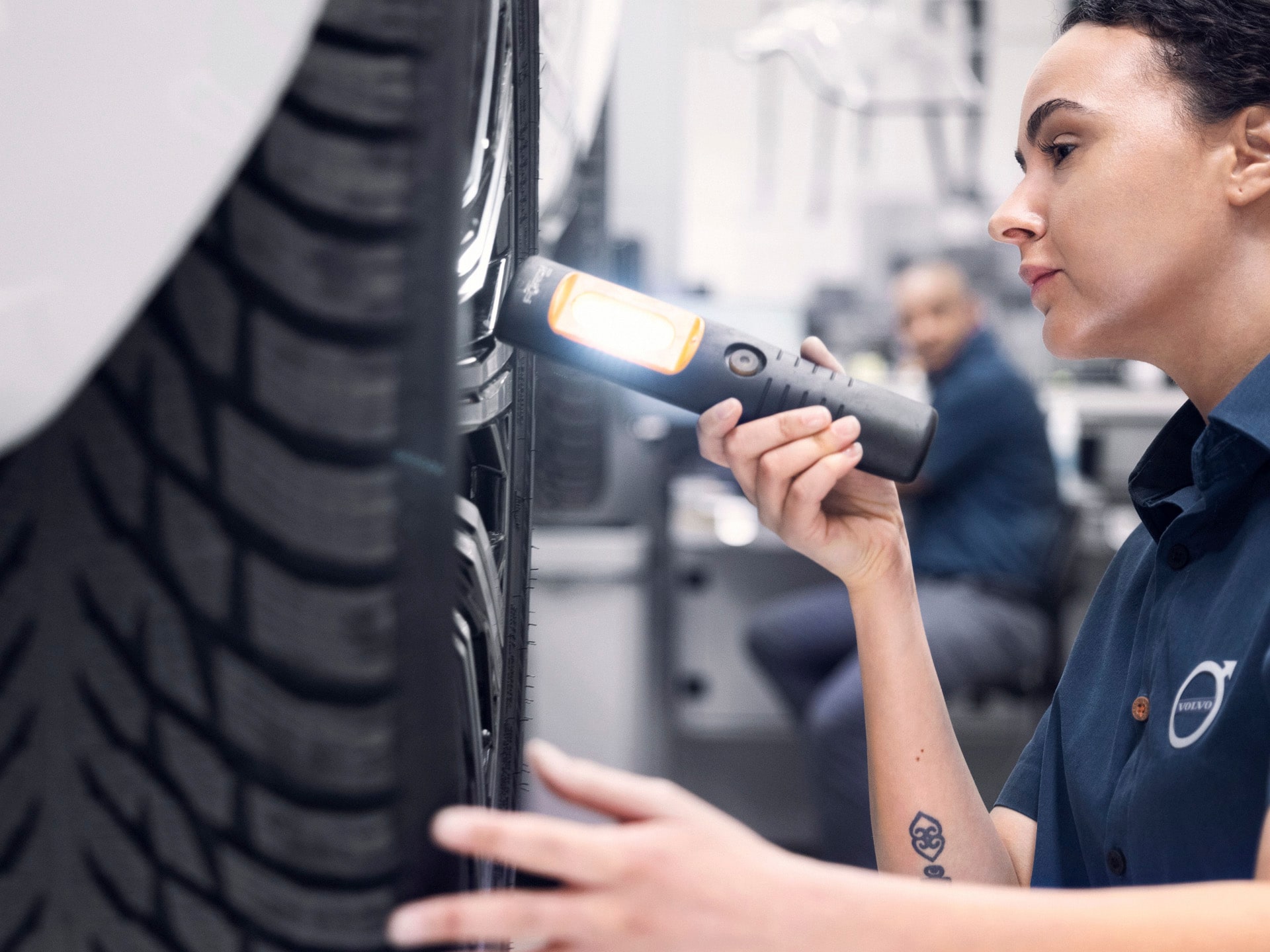 Una mecánica Volvo revisando un neumático