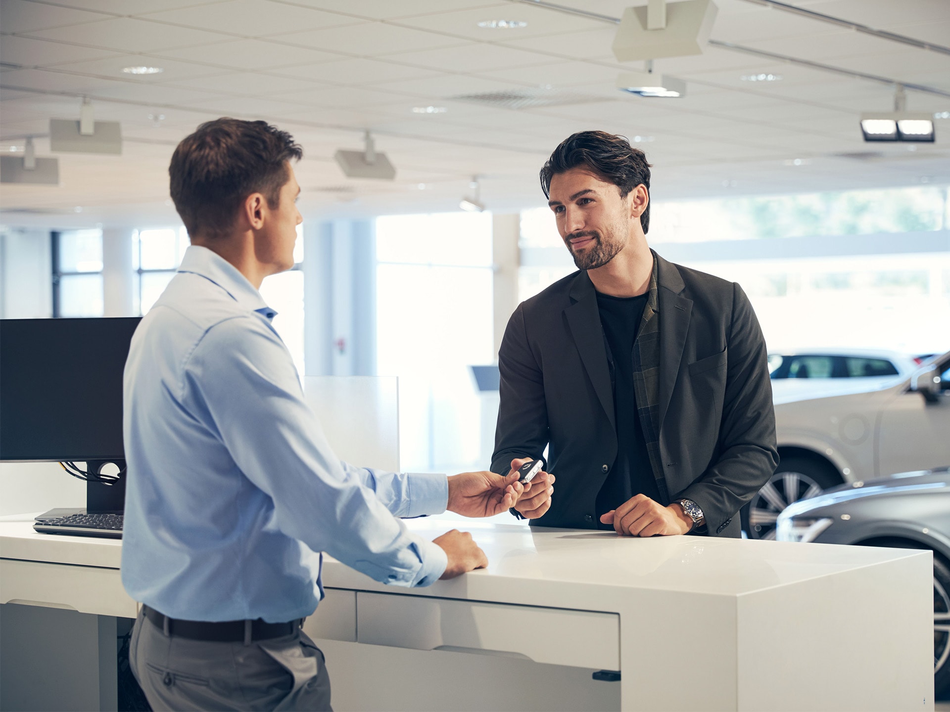 Un trabajador de un concesionario Volvo entrega una llaves a un cliente