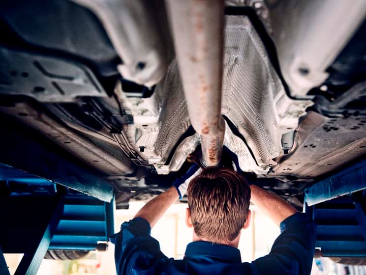 Mecánico Volvo revisando los bajos de un vehículo