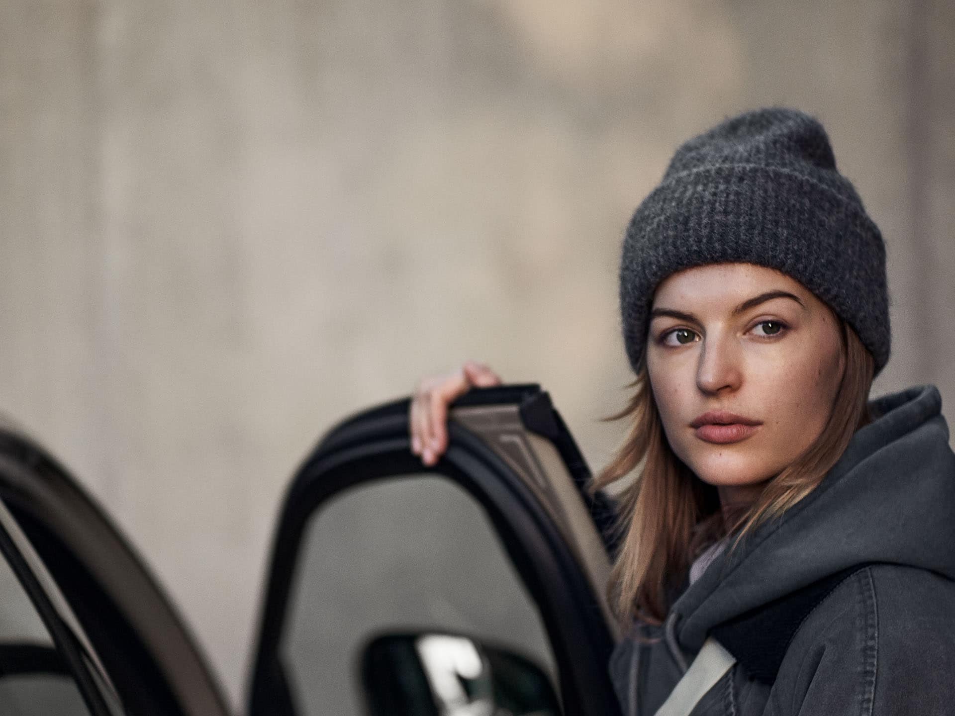 Una chica abriendo la puerta de un vehículo Volvo