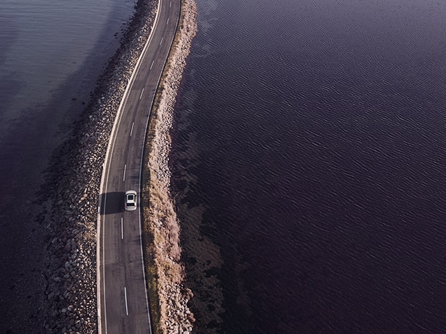 Volvo kör på en väg vid havet