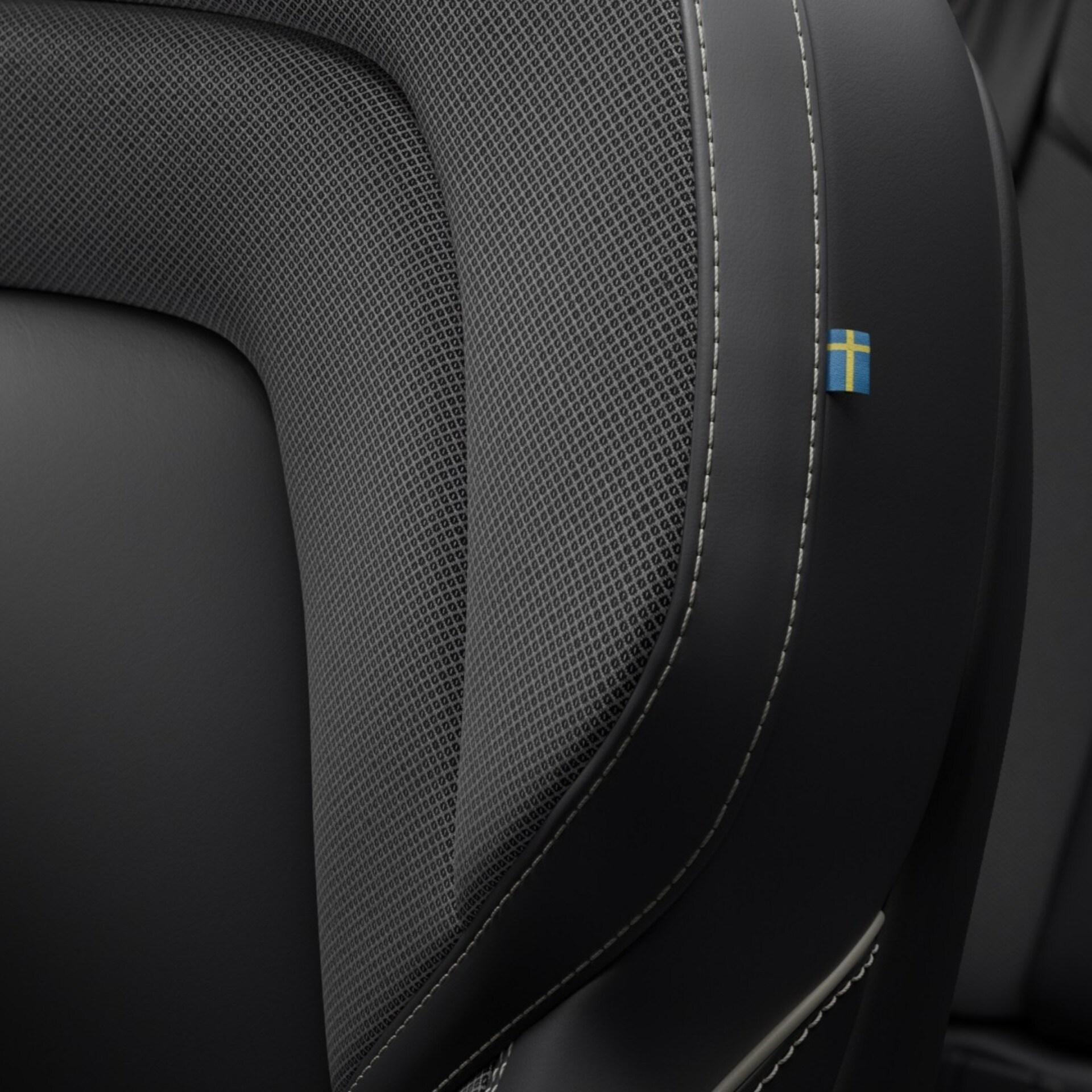 Volvo V60 高效輕油電的 Nappa 真皮前乘客座的縫線特寫，上面有一面瑞典小國旗。