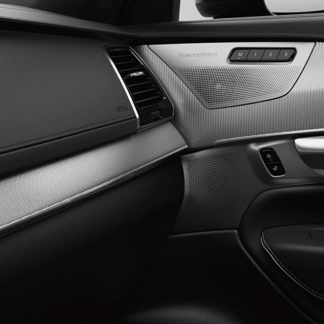 Volvo XC90 高效輕油電休旅車乘客側帶有木紋飾面的黑色和米色內飾儀錶板。