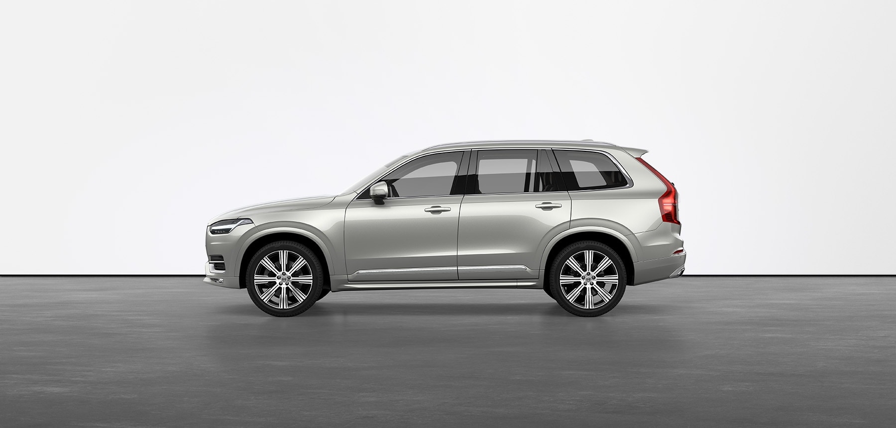 A birch light Volvo SUV XC90 standing still on grey floor in a studio